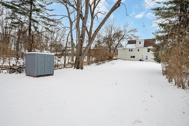 yard covered in snow featuring a shed