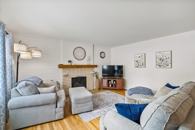 living room with a brick fireplace and hardwood / wood-style flooring