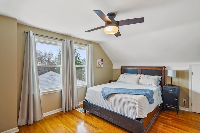 bedroom with ceiling fan, lofted ceiling, and wood-type flooring