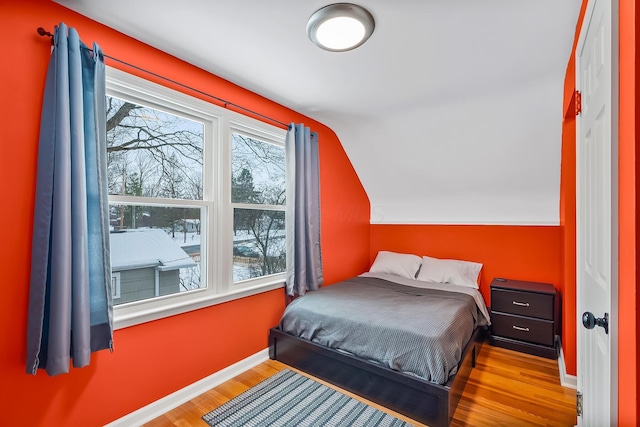 bedroom featuring light hardwood / wood-style floors and vaulted ceiling