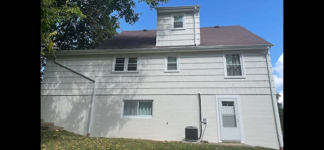 back of house featuring cooling unit and a yard