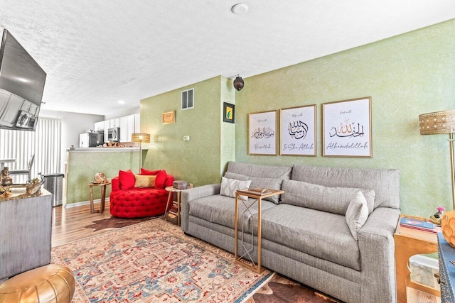 living room with hardwood / wood-style flooring and a textured ceiling