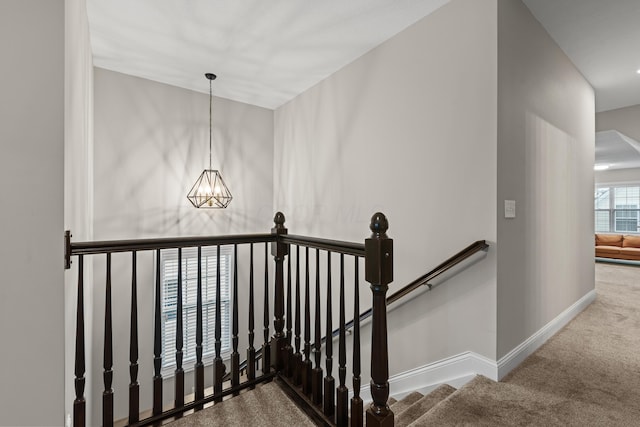 stairs featuring carpet flooring and a notable chandelier