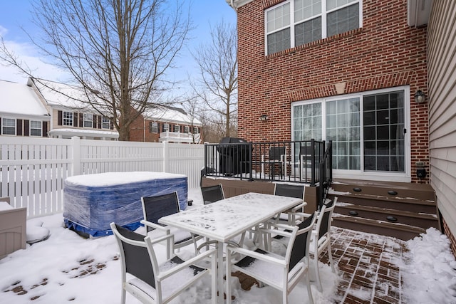 snow covered patio with a hot tub