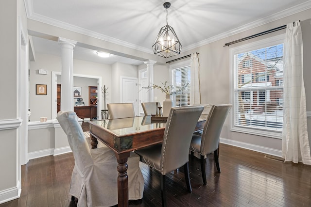 dining space with dark hardwood / wood-style floors, a wealth of natural light, and ornate columns