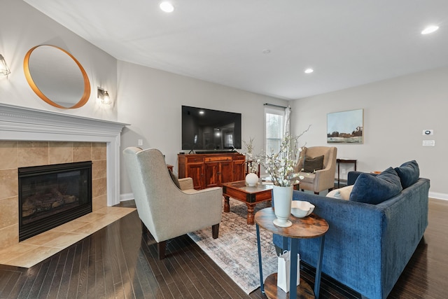 living room with dark hardwood / wood-style floors and a tiled fireplace