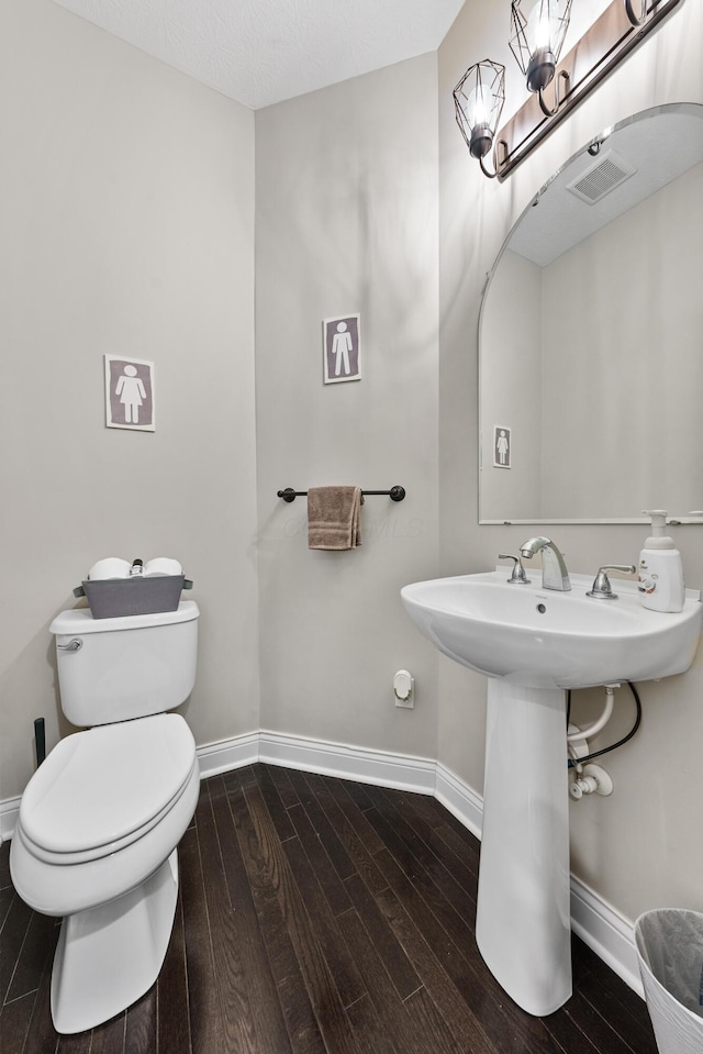 bathroom featuring hardwood / wood-style floors, toilet, and a textured ceiling