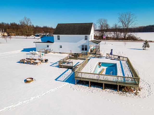 snow covered pool featuring a wooden deck and cooling unit