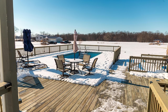 snow covered deck featuring a fenced in pool