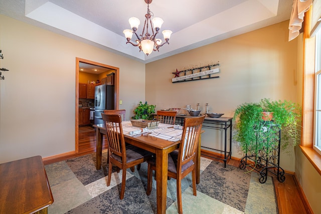 dining room featuring an inviting chandelier and a raised ceiling