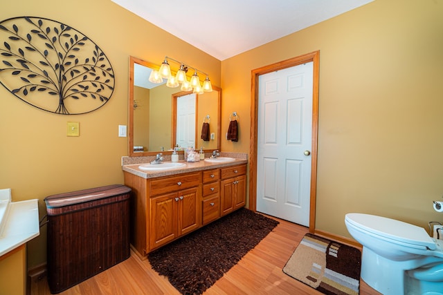 bathroom with wood-type flooring, toilet, and vanity