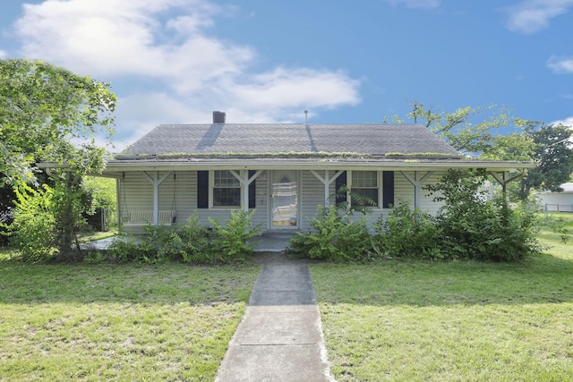 10 Main St, Orient, OH 43146 - view of front facade featuring covered porch, a front lawn, a chimney, and roof with shingles