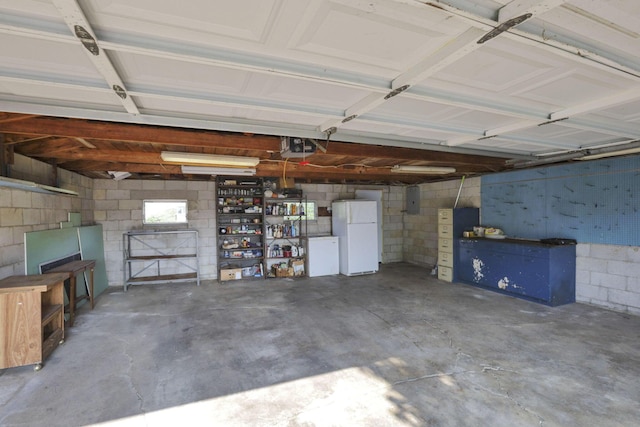 10 Main St, Orient, OH 43146 - garage featuring freestanding refrigerator, concrete block wall, and electric panel