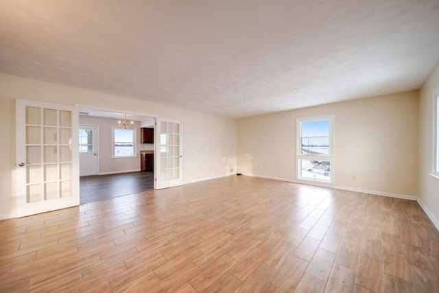 unfurnished room featuring an inviting chandelier and french doors