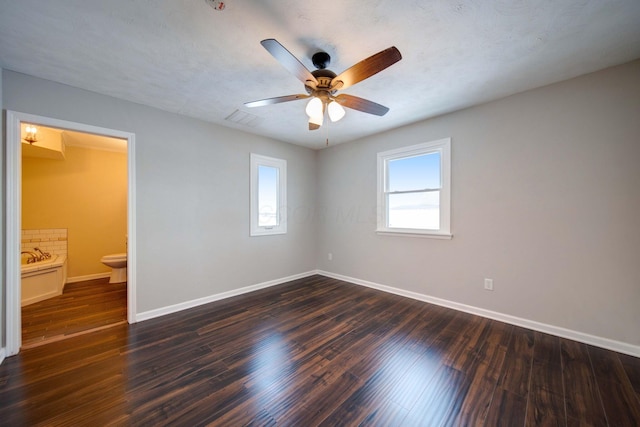 spare room featuring a textured ceiling, dark wood-type flooring, and ceiling fan