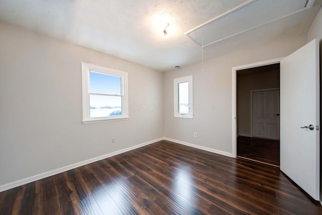 unfurnished room with a textured ceiling and dark hardwood / wood-style floors