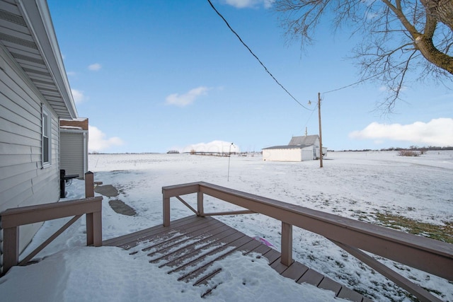 snow covered deck with a storage shed