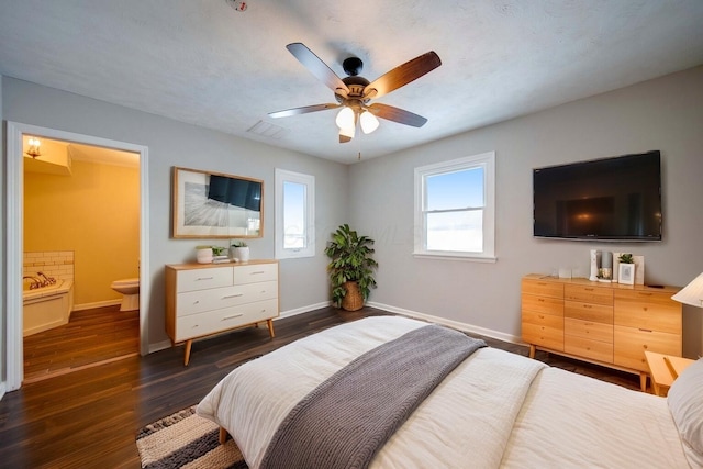 bedroom with ceiling fan, dark hardwood / wood-style floors, ensuite bathroom, and a textured ceiling