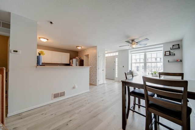 dining room with ceiling fan and light wood-type flooring