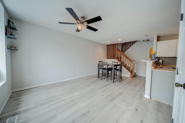 unfurnished dining area with light wood-type flooring and ceiling fan