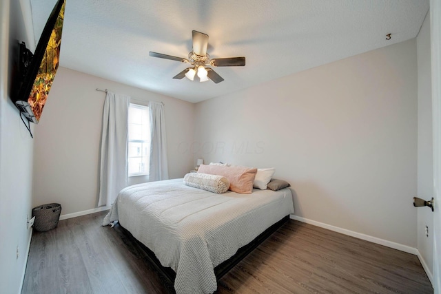 bedroom with ceiling fan and dark hardwood / wood-style flooring