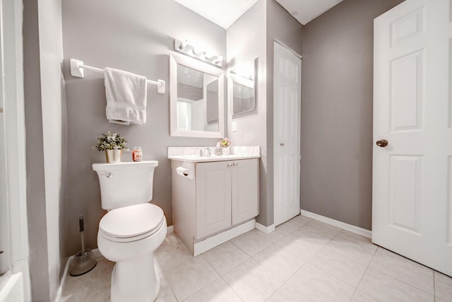 bathroom with toilet, vanity, and tile patterned floors