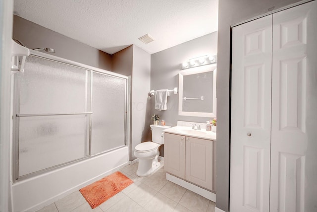 full bathroom featuring toilet, bath / shower combo with glass door, tile patterned flooring, and vanity