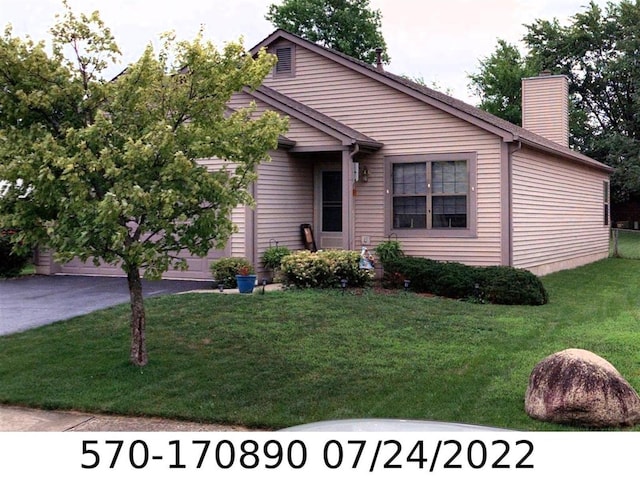 view of front of property with a garage and a front lawn