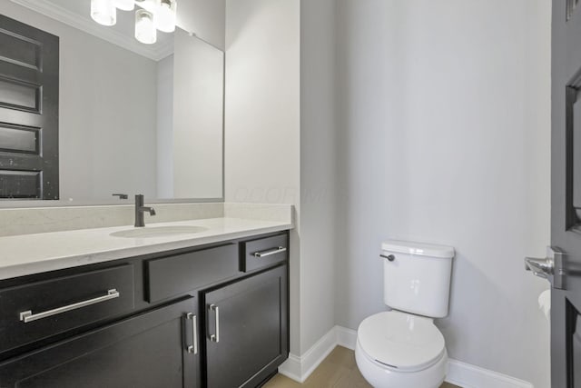 bathroom featuring vanity, crown molding, and toilet