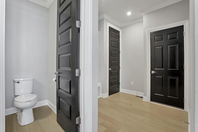 foyer with ornamental molding and light wood-type flooring