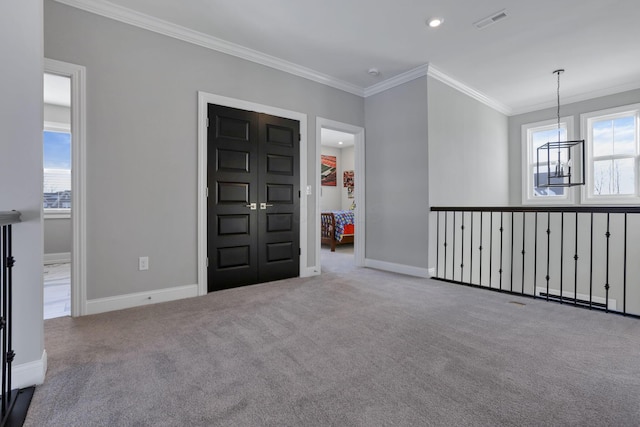 foyer with crown molding, light colored carpet, and a healthy amount of sunlight