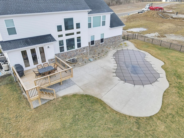 back of property with french doors, a deck, and a lawn