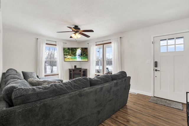 living room with ceiling fan and dark hardwood / wood-style flooring