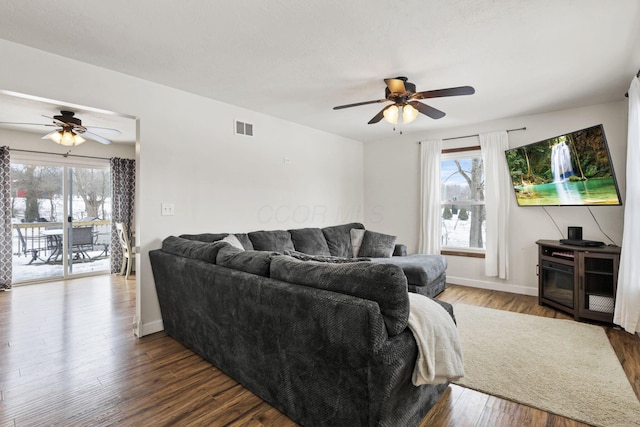 living room featuring ceiling fan and dark hardwood / wood-style flooring