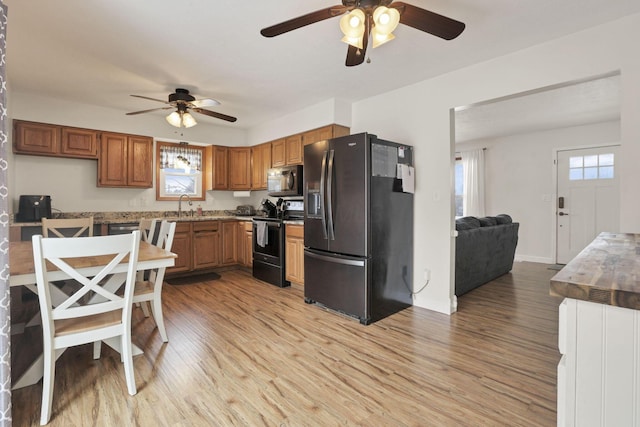 kitchen with sink, black fridge, light hardwood / wood-style flooring, electric stove, and ceiling fan