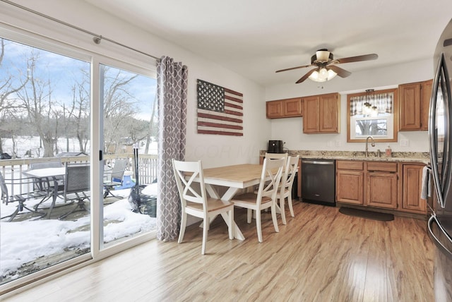 kitchen featuring sink, appliances with stainless steel finishes, ceiling fan, light stone countertops, and light hardwood / wood-style floors