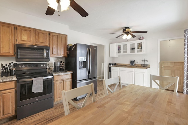 kitchen with stainless steel appliances, ceiling fan, and light hardwood / wood-style flooring