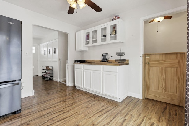 kitchen featuring ceiling fan, white cabinets, stainless steel refrigerator, and light hardwood / wood-style flooring