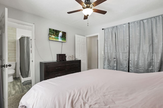 bedroom with hardwood / wood-style floors, ceiling fan, and ensuite bathroom