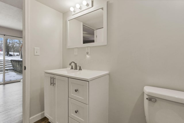 bathroom featuring vanity, wood-type flooring, and toilet