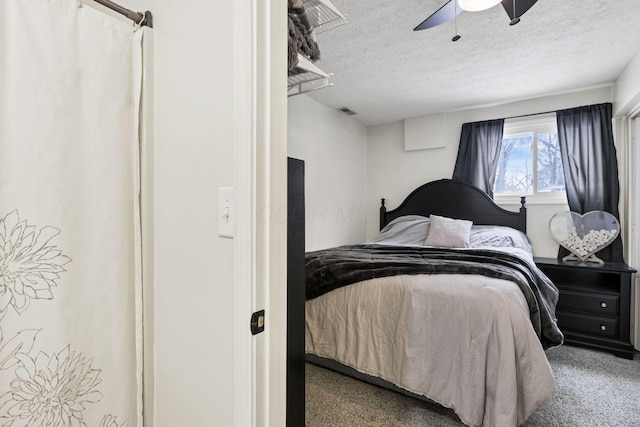 carpeted bedroom featuring ceiling fan and a textured ceiling