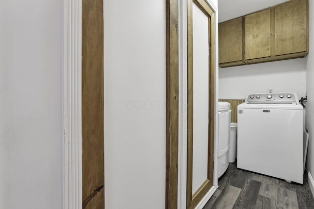 clothes washing area featuring cabinets, dark hardwood / wood-style floors, and washing machine and dryer