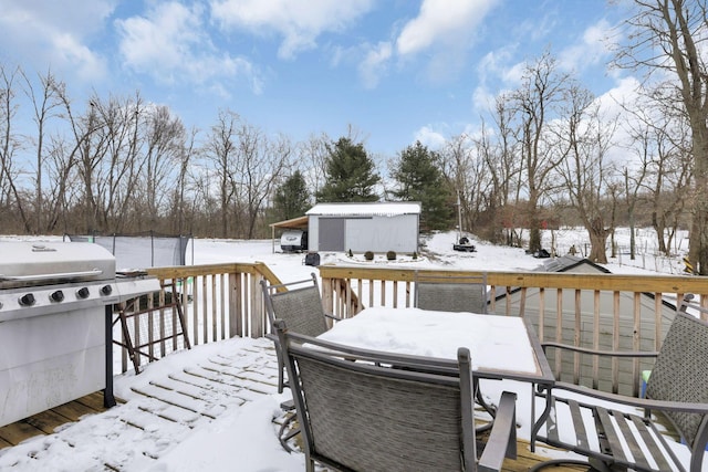 snow covered deck with a storage shed