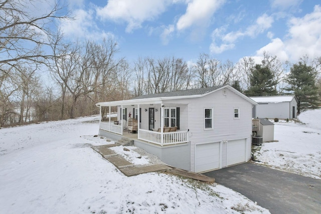 view of front of house featuring central AC unit, a garage, and covered porch