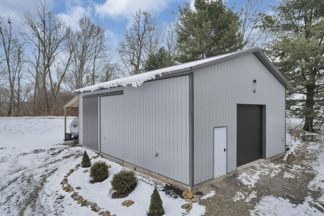 snow covered structure featuring a garage