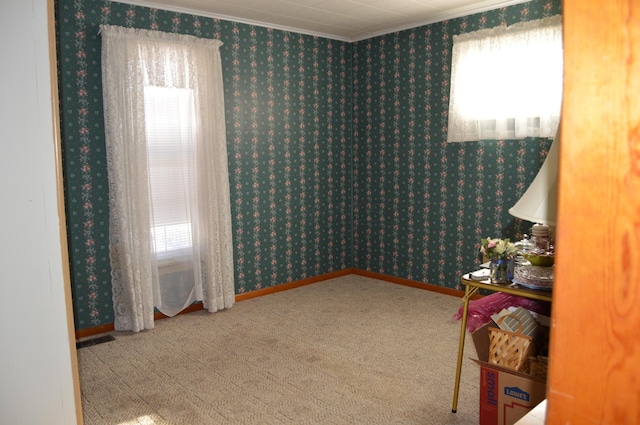 living area with a wealth of natural light, crown molding, and carpet flooring