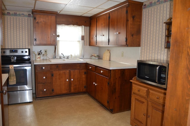 kitchen with sink, a drop ceiling, and appliances with stainless steel finishes