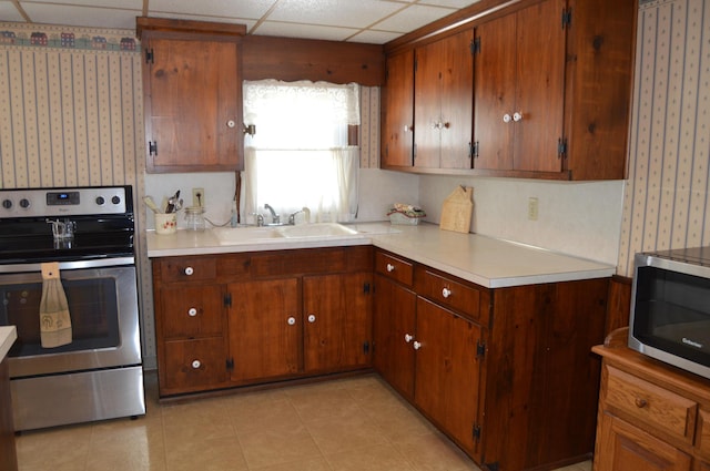 kitchen with sink, a paneled ceiling, and stainless steel appliances