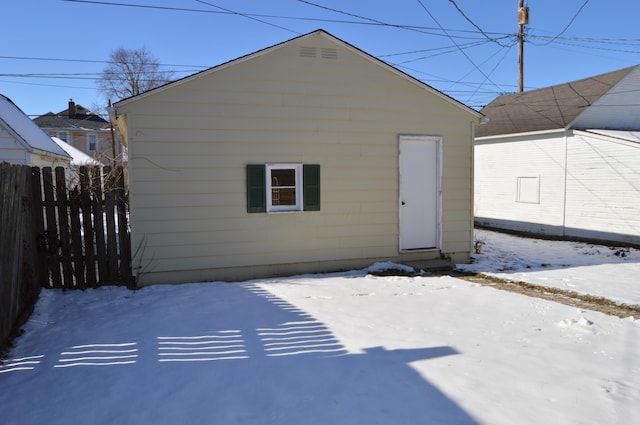 view of snow covered back of property