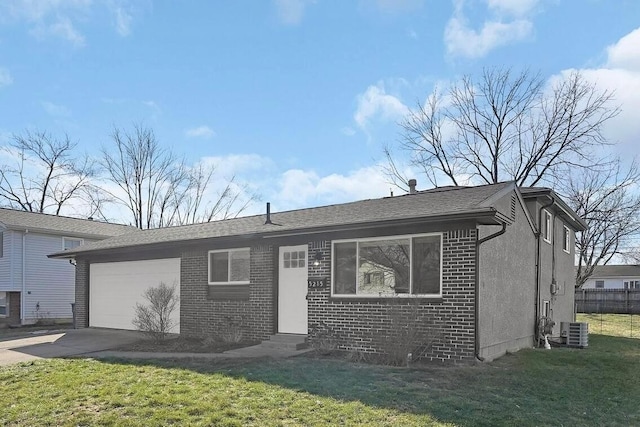 view of front of house featuring cooling unit, a garage, and a front lawn